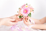 Fototapeta Tulipany - ピンクの花束を渡す子供の手　花のプレゼントイメージ素材