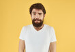 © SHOTPRIME STUDIO - portrait of a man white t-shirt yellow background cropped view Copy Space