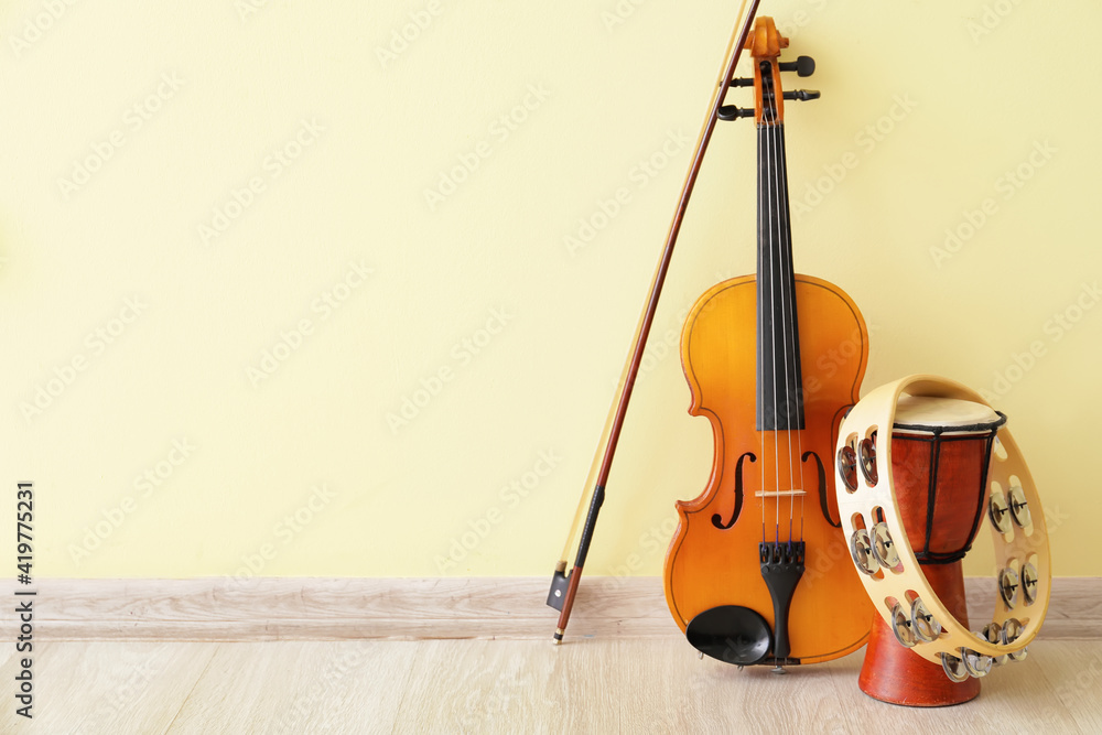 Different musical instruments near color wall