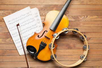 Wall Mural - Violin, tambourine and music notes on wooden background