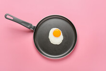 Frying Pan With Tasty Egg On Color Background