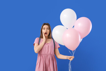 Poster - Surprised young woman with balloons on color background