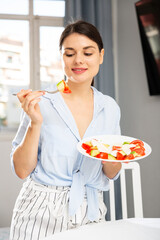 Nice girl eating tomato and avocado salad