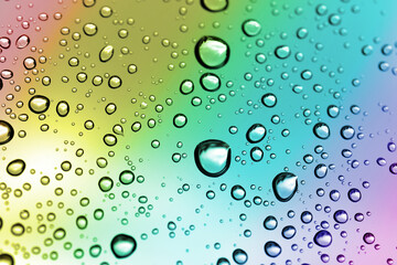 Sticker - Water drops on a window glass after the rain. Nature background in rainbow color.