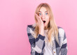 © Studio Nova - Portrait of young surprised blonde woman in plaid shirt isolated on pink background