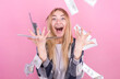 © Studio Nova - Portrait of pretty charming positive cute successful lucky cheerful girl standing under shower from money having a lot of money in hands isolated on pink background