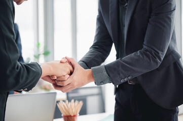 Wall Mural - Business man in a suit shakes hands to agree a business partnership agreement. Business etiquette concept of congratulation, concept of handshake during office meeting.