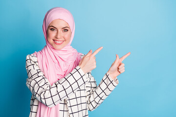 Poster - Portrait of attractive cheerful glad muslimah girl showing copy space advert solution isolated over shine blue color background