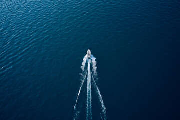 Wall Mural - Aerial view of luxury floating ship at sunset, blue sea. High altitude air view. Yacht at the sea in Europe. Drone view of a boat sailing across the blue clear waters.