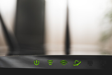 Close up shot of internet router and green icons of WIFI connection. Internet cable on router