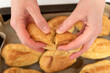 © somemeans - Middle of workpiece for profiteroles in hands of Chef. Puffs, popovers, eclair. Close up.