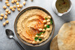 hummus in a ceramic bowl on a light background, top view