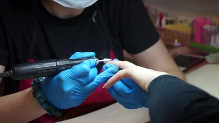 Wall Mural - The manicurist removes the old gel from the nails using the hardware method