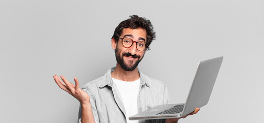 Poster - young crazy bearded man afraid or confused expression. laptop concept