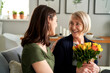 © gpointstudio - Woman giving mother bouquet of flowers
