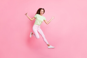 Sticker - Full length portrait of charming young girl jumping high toothy smile raise hands palms isolated on pink color background