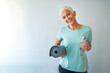 © Dragana Gordic - An elderly woman poses for a portrait after her workout. Fit Mature Woman With Exercise Mat. Confident Woman With Exercise Mat Smiling In Gym