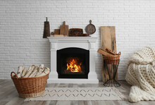 Wicker Baskets With Firewood And White Fireplace In Cozy Living Room