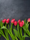 Fototapeta Tulipany - pink tulips on black stone surface