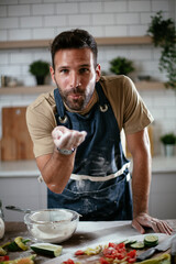 Wall Mural - Young man preparing bread at home. Happy man having fun while baking a fresh pasta..