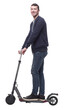 © ASDF - smiling young man with an electric scooter .