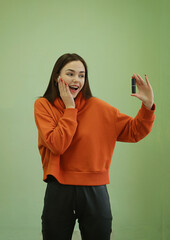 Wall Mural - A beautiful young girl holds lipstick in her hands. Emotional portrait.