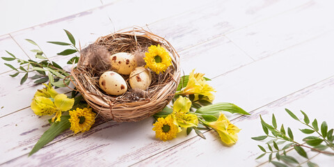 Easter eggs in a nest of straw and flowers 