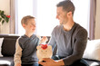 Father with little son with piggy bank at home