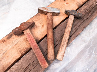 Three hammers on wooden boards.