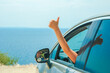 © Kostia - A happy girl from car at sea greece background