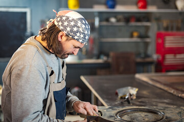 Wall Mural - Male carpenter working on old wood in a retro vintage workshop.