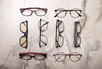 Poster - Different multi-colored eyeglass frames on gray background.