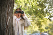 © New Africa - Jealous woman with binoculars spying on ex boyfriend in park
