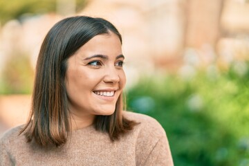 Young hispanic woman smiling happy standing at the city.