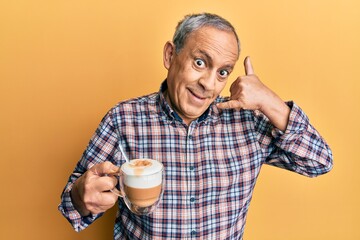 Sticker - Handsome senior man with grey hair drinking a cup coffee smiling doing phone gesture with hand and fingers like talking on the telephone. communicating concepts.