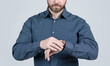 Bearded man cropped view in casual shirt check time on watch grey background, timekeeping