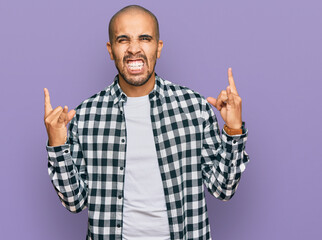 Sticker - Hispanic adult man wearing casual clothes shouting with crazy expression doing rock symbol with hands up. music star. heavy concept.