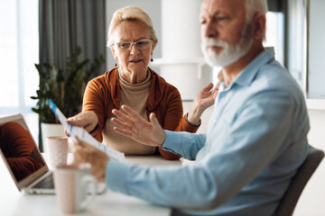 Wall Mural - Frustrated senior couple arguing about their home finances at home