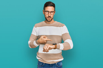 Poster - Handsome man with beard wearing casual clothes and glasses in hurry pointing to watch time, impatience, upset and angry for deadline delay