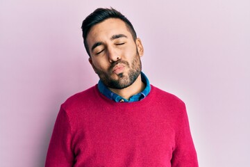 Poster - Young hispanic man wearing casual clothes looking at the camera blowing a kiss on air being lovely and sexy. love expression.