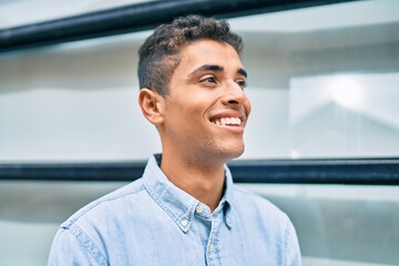 Poster - Young latin man smiling happy walking at the city.