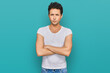 © Krakenimages.com - Young handsome man wearing casual white t shirt skeptic and nervous, disapproving expression on face with crossed arms. negative person.