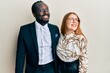 © Krakenimages.com - Young interracial couple wearing business and elegant clothes smiling looking to the side and staring away thinking.
