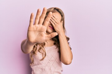 Sticker - Young blonde girl wearing casual clothes covering eyes with hands and doing stop gesture with sad and fear expression. embarrassed and negative concept.