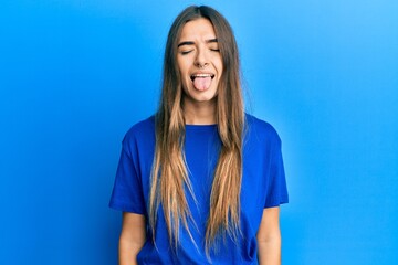 Young hispanic woman wearing casual clothes sticking tongue out happy with funny expression. emotion concept.