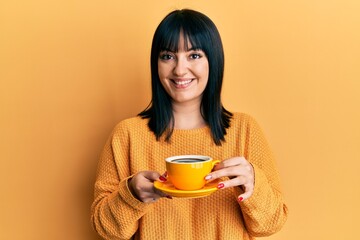 Sticker - Young hispanic woman holding coffee smiling with a happy and cool smile on face. showing teeth.