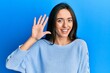 © Krakenimages.com - Young hispanic girl wearing casual clothes showing and pointing up with fingers number five while smiling confident and happy.