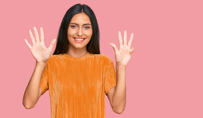 Sticker - Young brunette arab woman wearing casual clothes showing and pointing up with fingers number nine while smiling confident and happy.