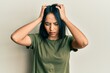 © Krakenimages.com - Young hispanic girl wearing casual t shirt suffering from headache desperate and stressed because pain and migraine. hands on head.