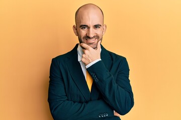 Sticker - Young hispanic man wearing business suit and tie looking confident at the camera smiling with crossed arms and hand raised on chin. thinking positive.